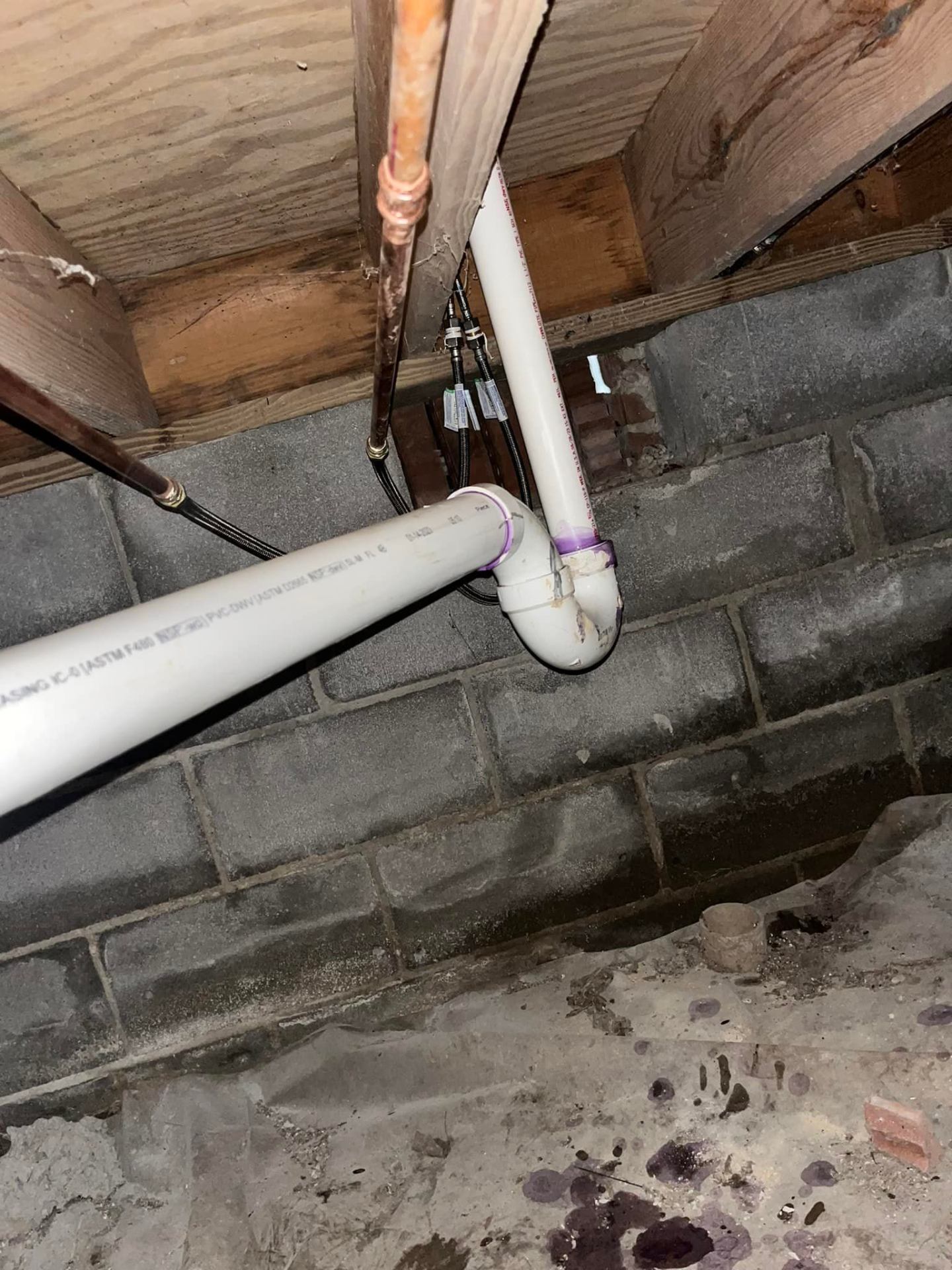 Sewer line PVC pipe work in crawlspace by Waterman Plumbing